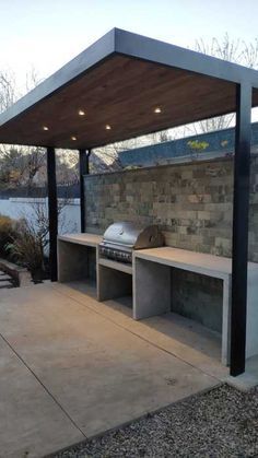 an outdoor bbq area with benches and grill