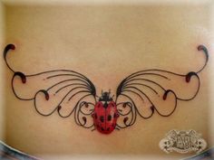 a ladybug tattoo on the back of a woman's stomach