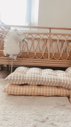 two pillows on the floor in front of a crib