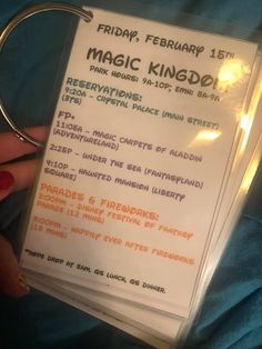 a hand holding a ticket for the magic kingdom festival in front of a blue blanket