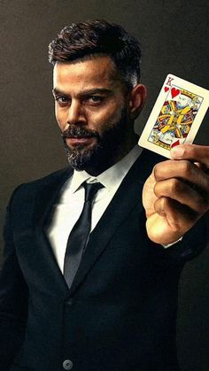 a man in a suit holding up a playing card