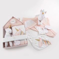 a baby's gift set with bib, bibs and toy unicorns