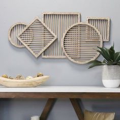 a table with some vases and plates on top of it next to a wall