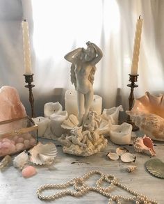 an assortment of seashells and candles on a table