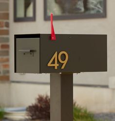 a mailbox with the number forty nine on it and a red plastic object sticking out