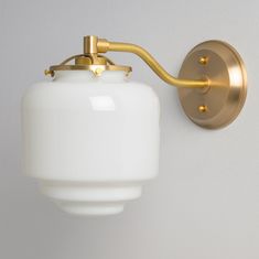 a white and gold light fixture on the wall