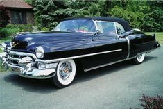 an old black car is parked on the street