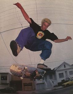 a man flying through the air while riding a skateboard in front of a house