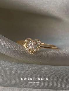 a gold ring with a heart shaped diamond on it's side and the words sweet peps written below