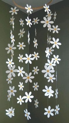 a mobile made out of paper with flowers hanging from it's sides in a room