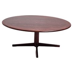 an oval wooden table with black legs and a brown top, against a white background