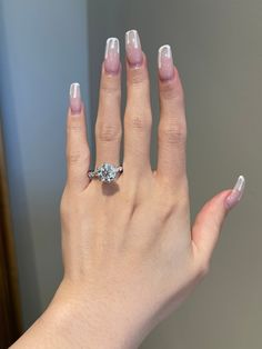 a woman's hand with a ring on top of her finger and nails in the middle