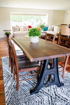 a dining room table with chairs and a potted plant on top of the table