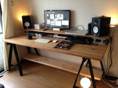 a computer desk with two monitors and speakers