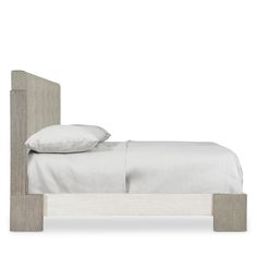 the bed is made up with white linens and wood headboard, along with two pillows