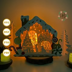 a lit up christmas house with lights and decorations on the table next to it is an ornament that says svg dx png