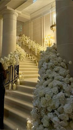 white flowers and candles are lined up along the stairs in this elegant wedding ceremony venue