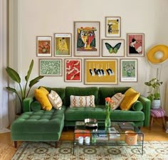 a living room with green couches and pictures on the wall