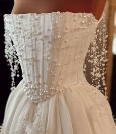 the back of a wedding dress with pearls on it