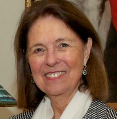 a woman in a suit smiling for the camera