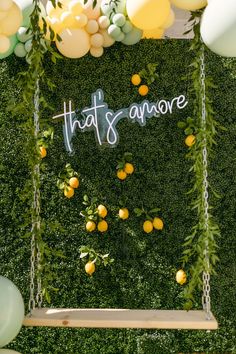 an arrangement of balloons and greenery with the words that's amore written on it