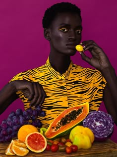 a woman is holding a piece of fruit in front of her face