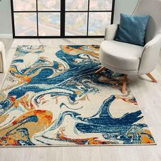 a modern rug with an abstract design in blue, yellow and orange colors on the floor