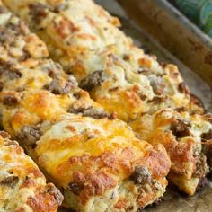 cheesy meat and cheese bread on a baking sheet, ready to be eaten