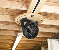 a ceiling fan mounted to the side of a wooden ceiling