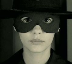 a woman wearing a black hat and mask