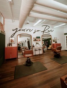 a hair salon with chairs and mirrors on the wall that says you're so raw