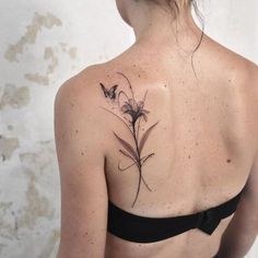 a woman with a butterfly tattoo on her back