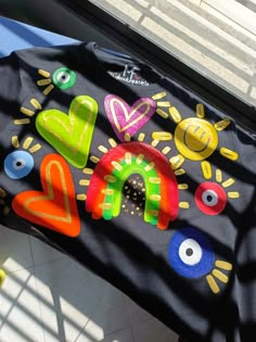 a black bag with colorful painted letters and eyes on the front is sitting on a window sill