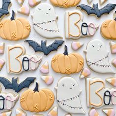 decorated halloween cookies with bats, pumpkins and ghost's on white paper background