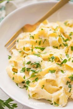 a white plate topped with pasta covered in cheese