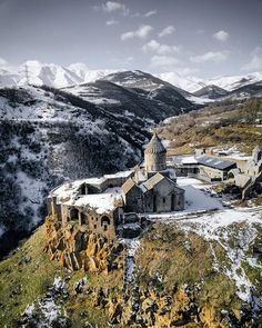 an old church on top of a mountain covered in snow