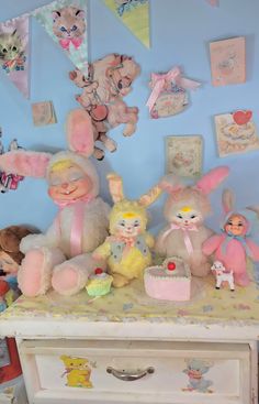 several stuffed animals and toys on a dresser in a child's room with blue walls