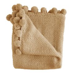 a tan blanket with pom poms on it