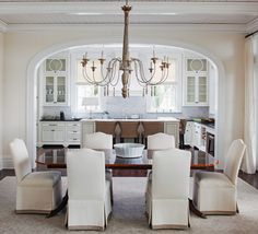 the dining room table is surrounded by white chairs