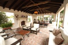 an outdoor living area with couches, tables and chairs