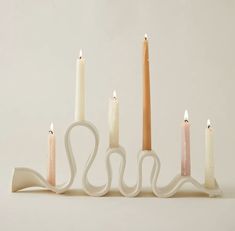 five candles are lined up in the shape of a spiral with one candle on each side