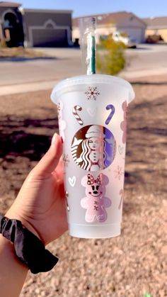 a person holding up a starbucks cup in the desert