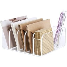 three pen holders with pens and magazines in them on a white surface, one is holding several folders