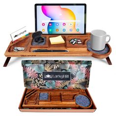 an open laptop computer sitting on top of a wooden desk next to a cup and other items