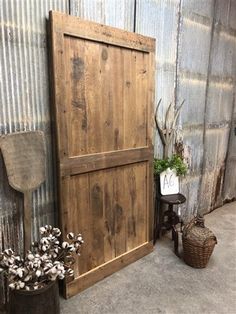 an old wooden door next to a chair and potted plant