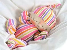 a colorful stuffed animal laying on top of a white blanket