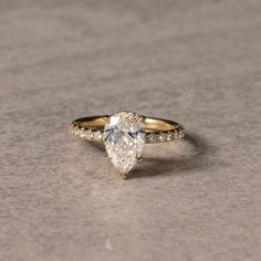 an engagement ring with a pear shaped diamond