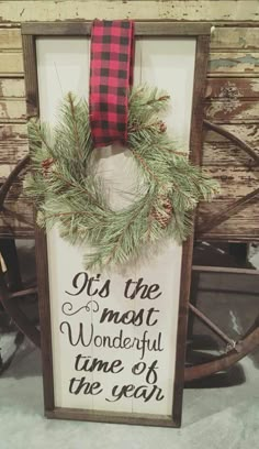 a wooden sign with a red and black ribbon hanging from it's center piece