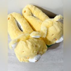 four yellow stuffed animals sitting on top of a white tablecloth covered bedding area