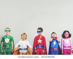 group of children dressed up as superheros posing for the camera with their hands on their faces